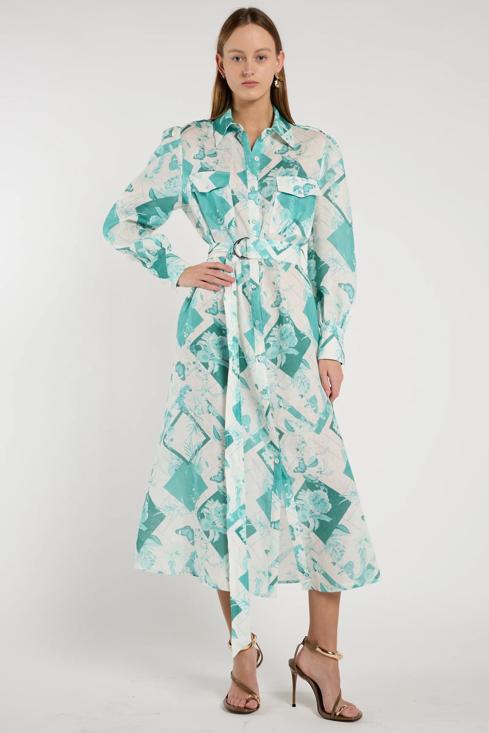 Woman wearing a long, patterned dress with a white background