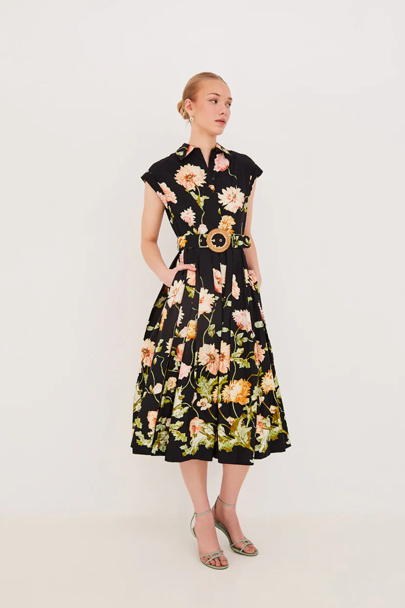 Woman wearing a black floral dress with a belt on a white background