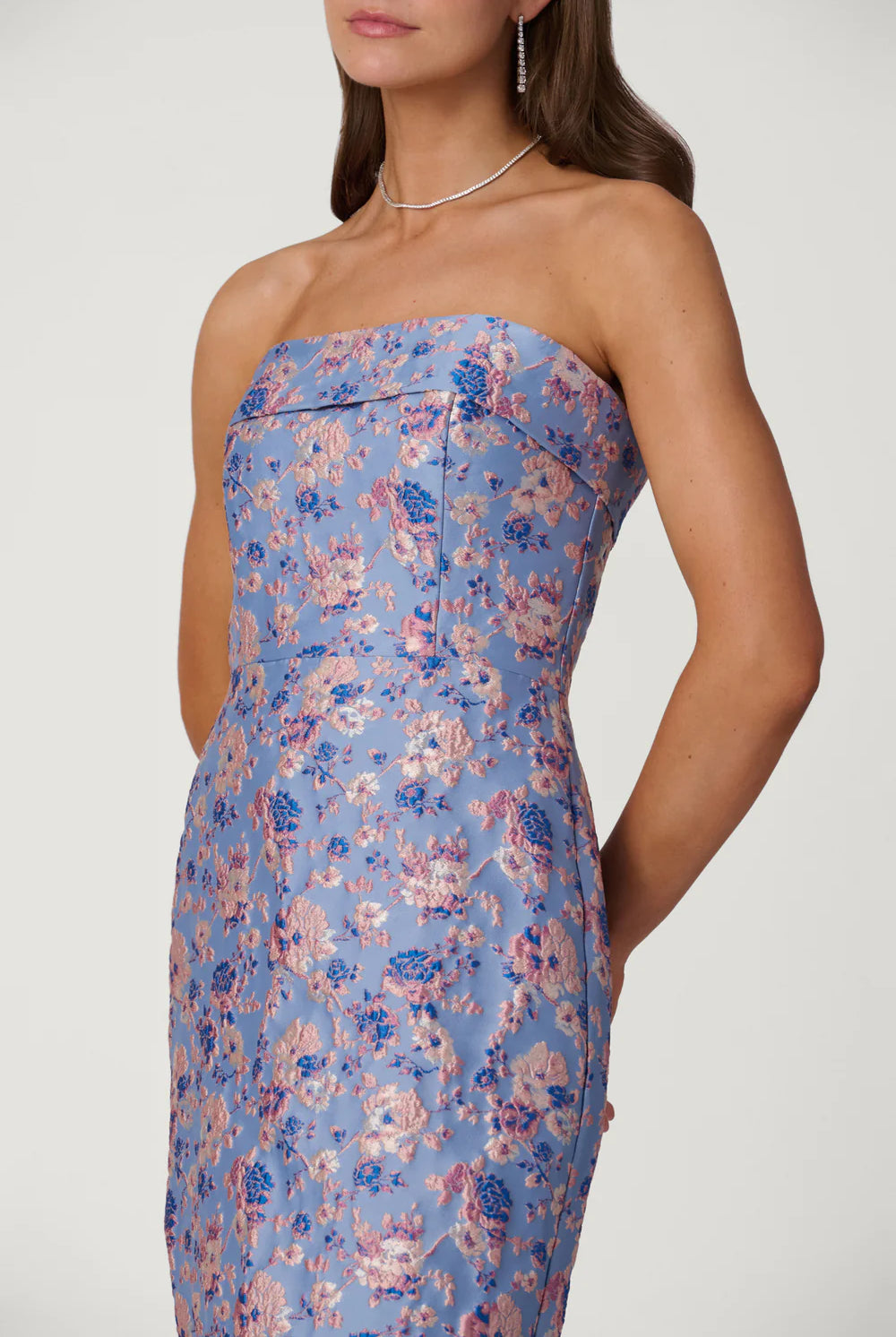 Woman wearing a strapless floral dress with a white background