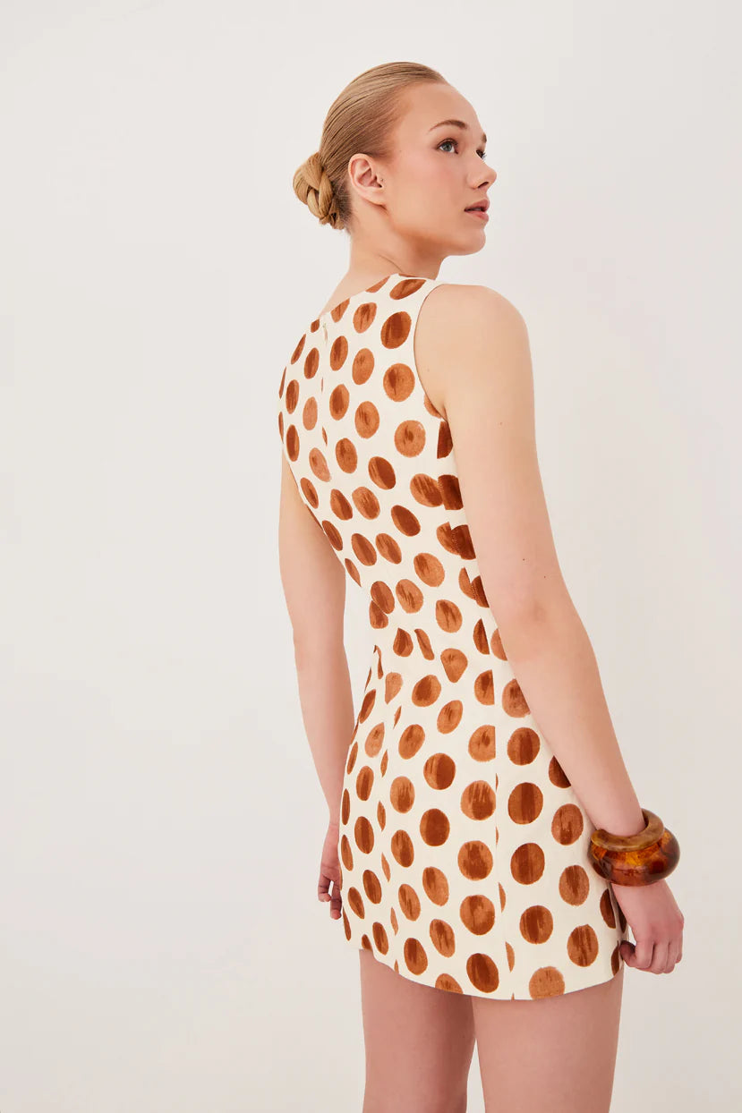 Woman wearing a polka dot dress on a plain background