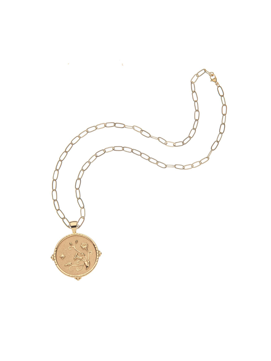Gold necklace with a round pendant on a white background