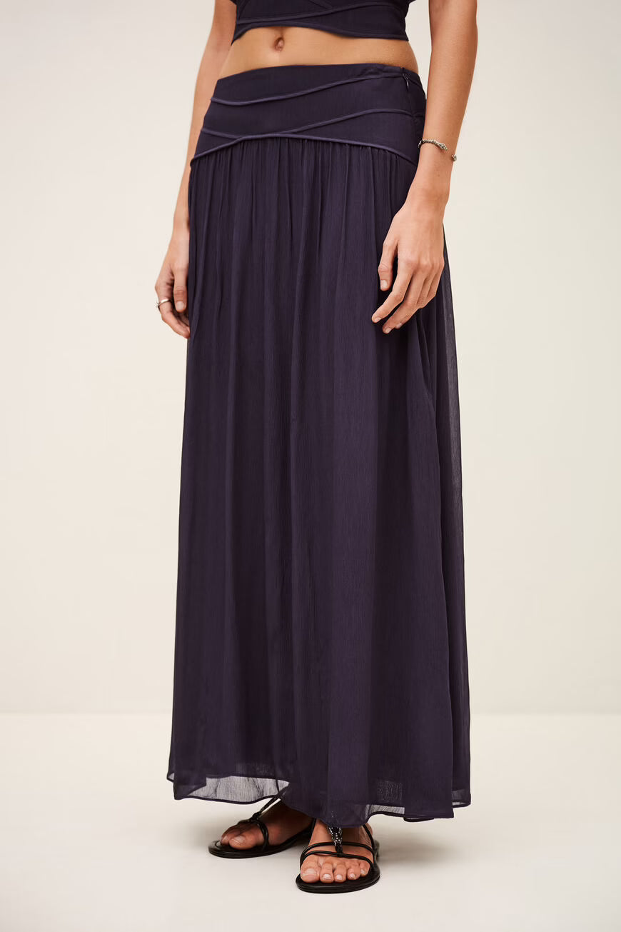 Navy blue skirt worn by a person on a plain background