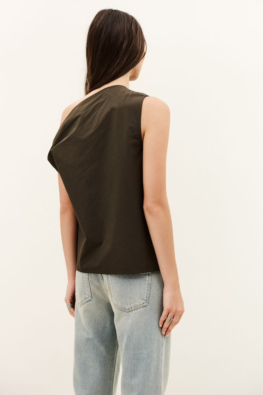 Woman wearing a brown sleeveless top and light blue jeans on a white background
