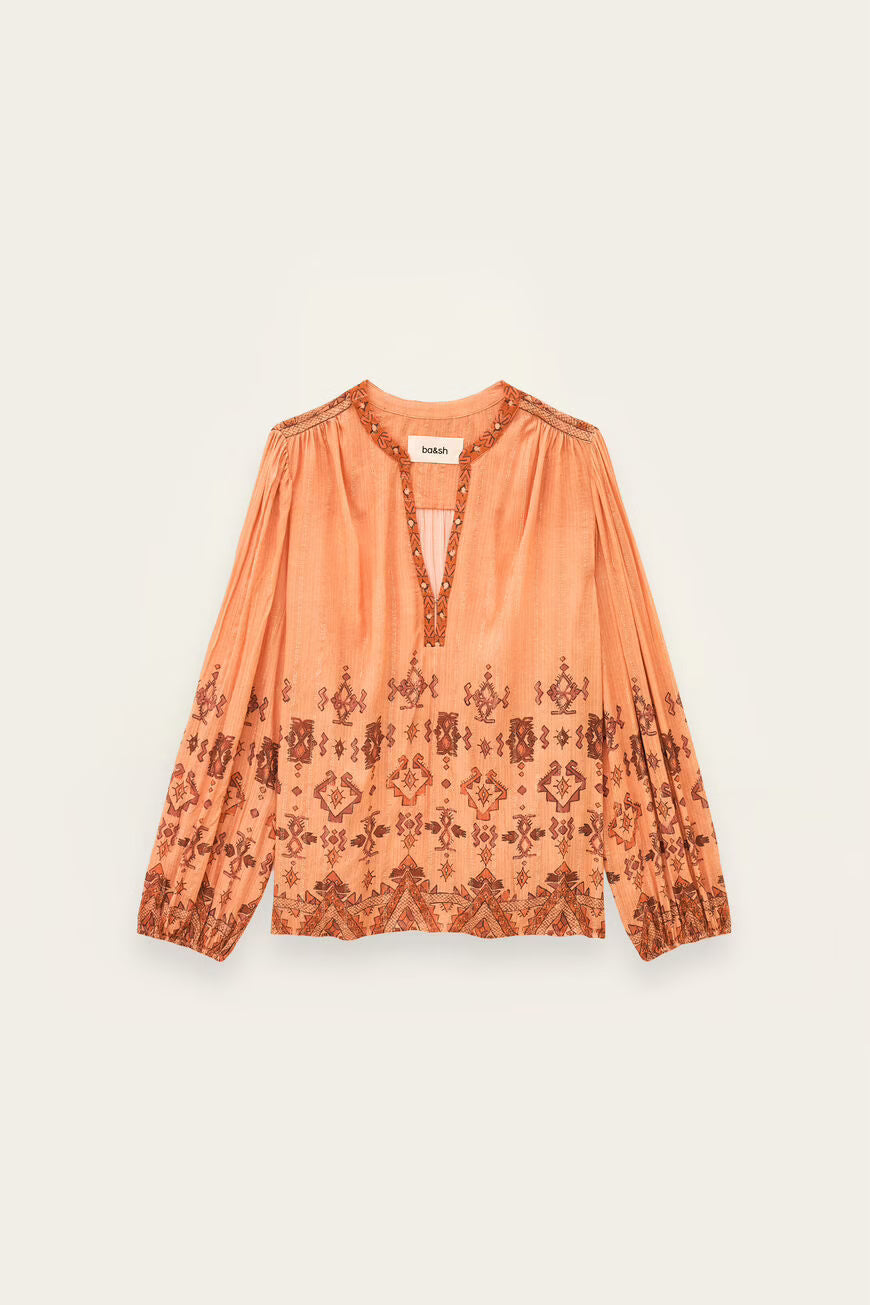 Orange blouse with pattern on a light beige background