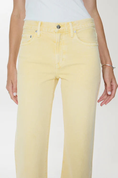 Yellow jeans worn by a person on a white background