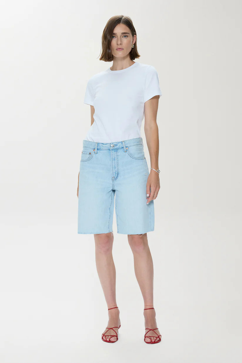 Woman wearing a white t-shirt and light blue denim shorts on a white background