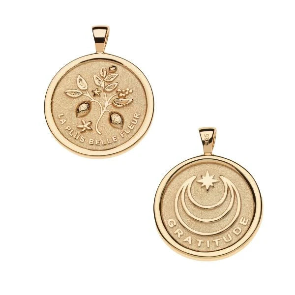 Two gold pendants with engraved designs on a white background
