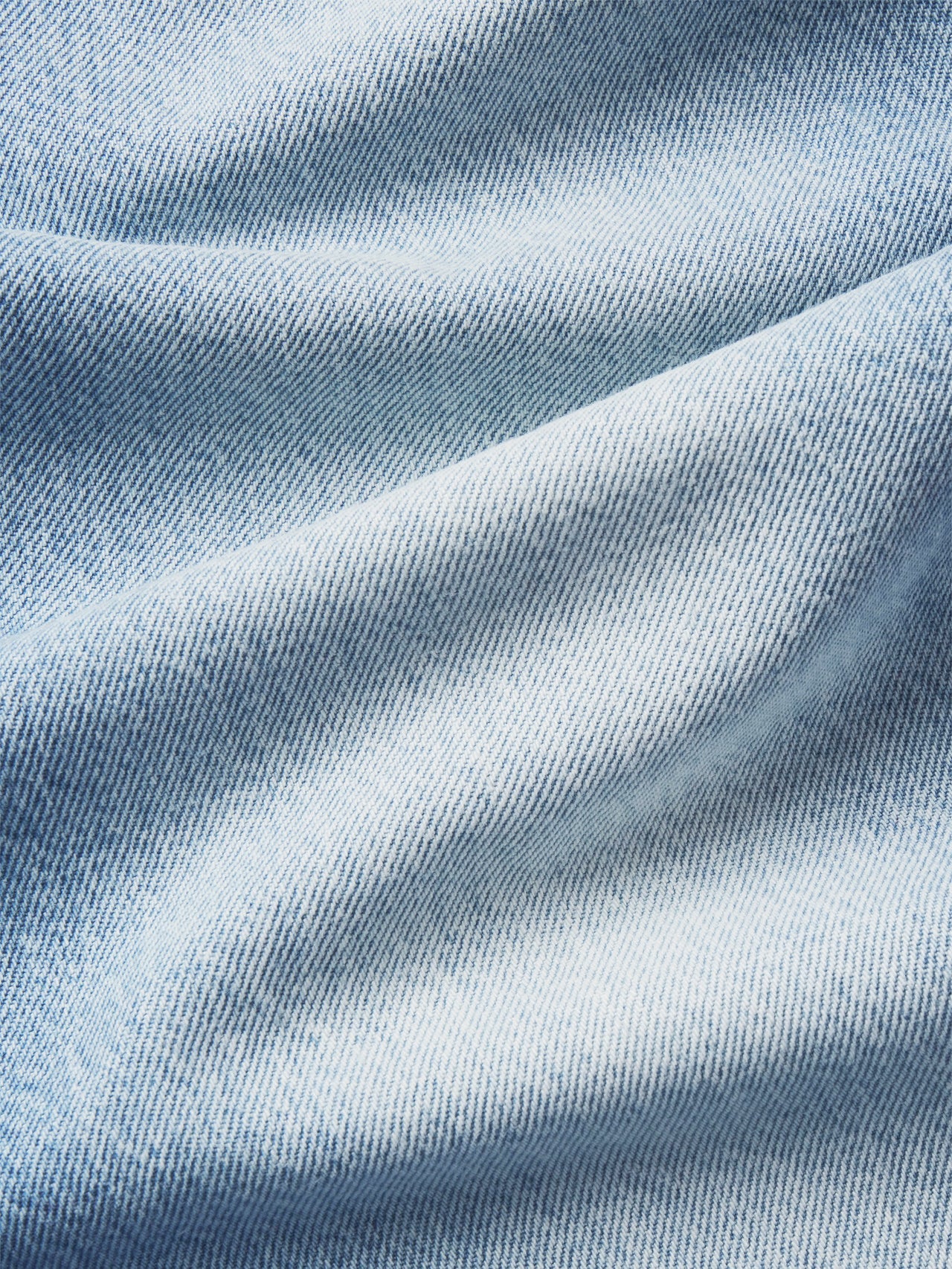 Close-up of light blue denim fabric with visible texture