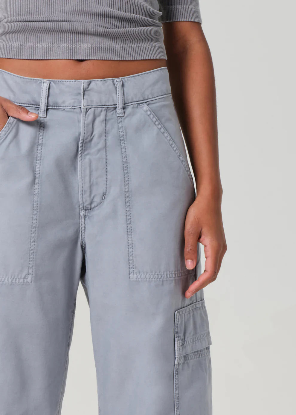 Gray cargo pants worn by a person on a plain background