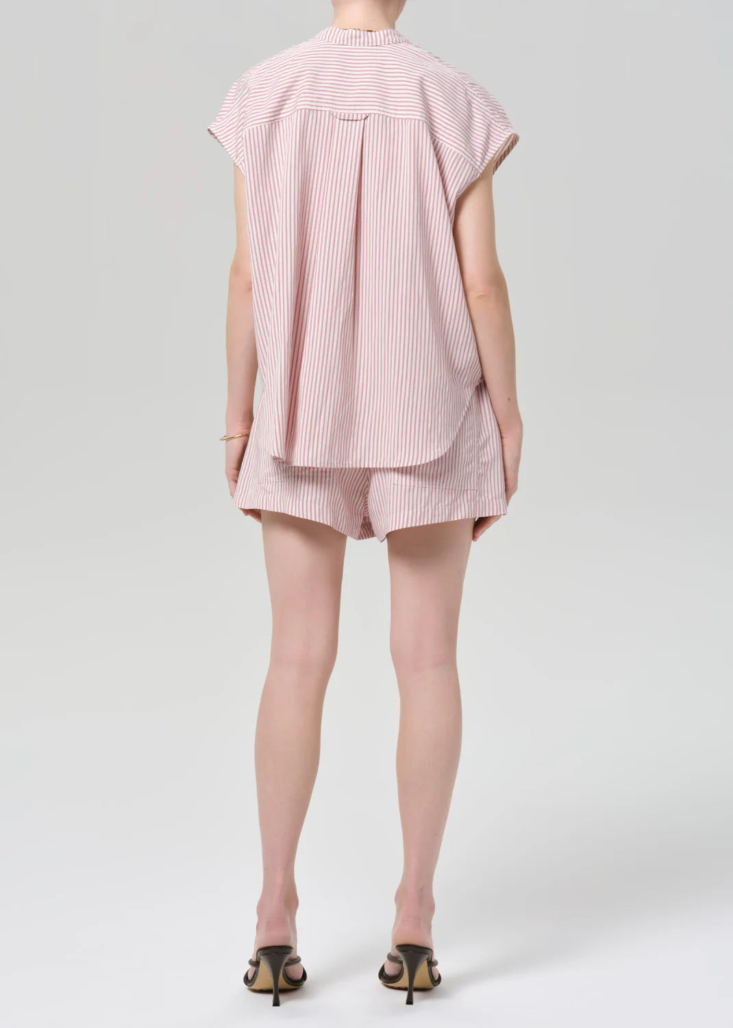 Person wearing a pink striped outfit on a white background