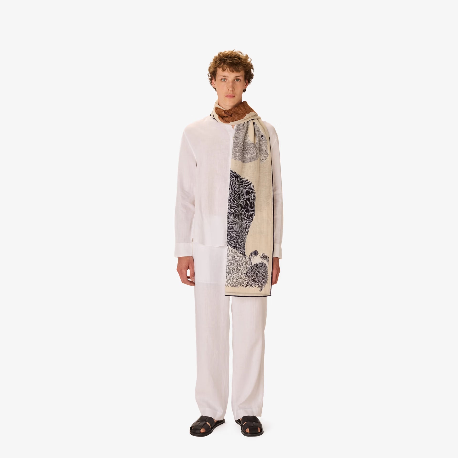 Person wearing a long white coat with a patterned scarf on a white background