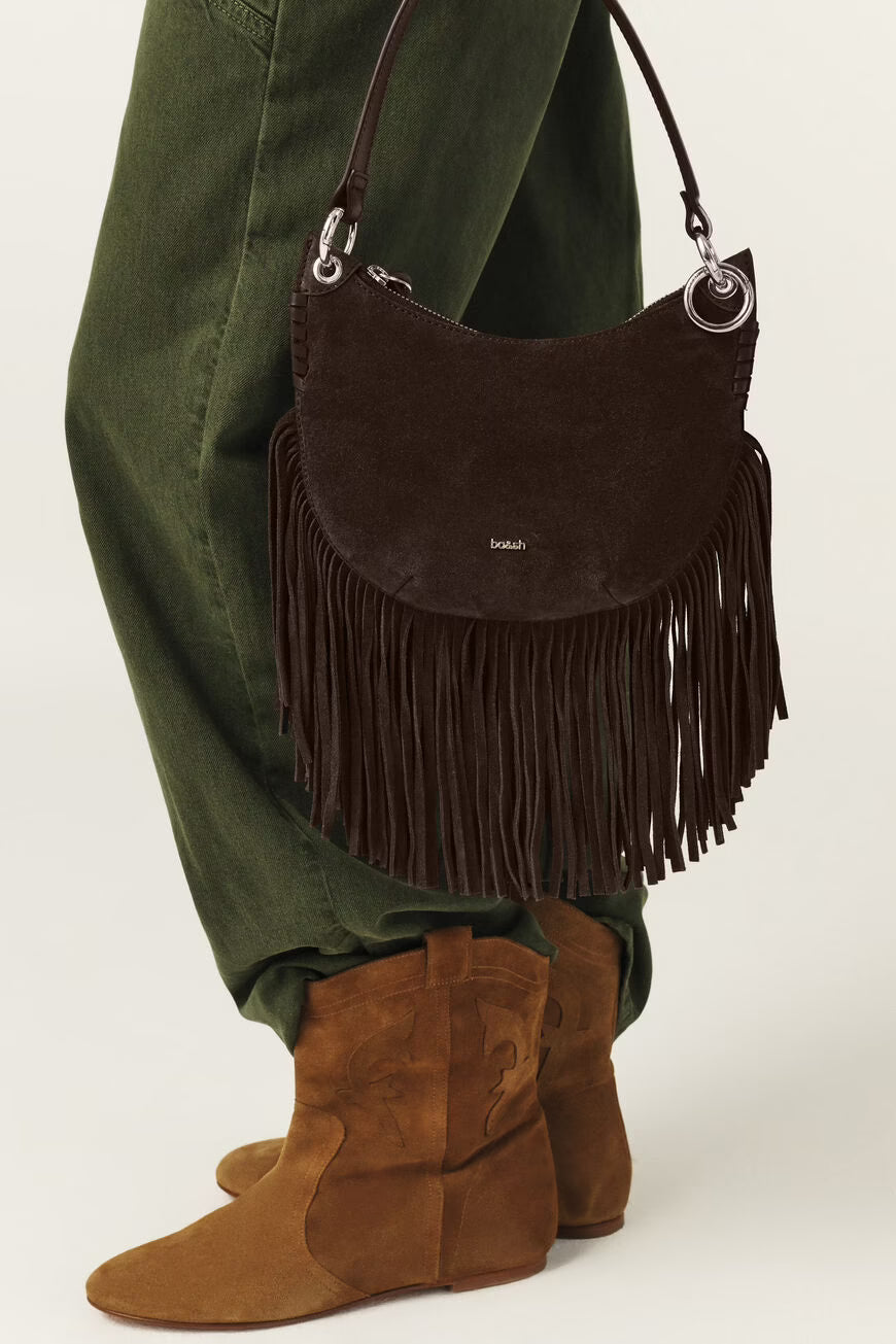 Brown suede handbag with fringe and 'Bodum' branding held by a person wearing green pants and brown boots.