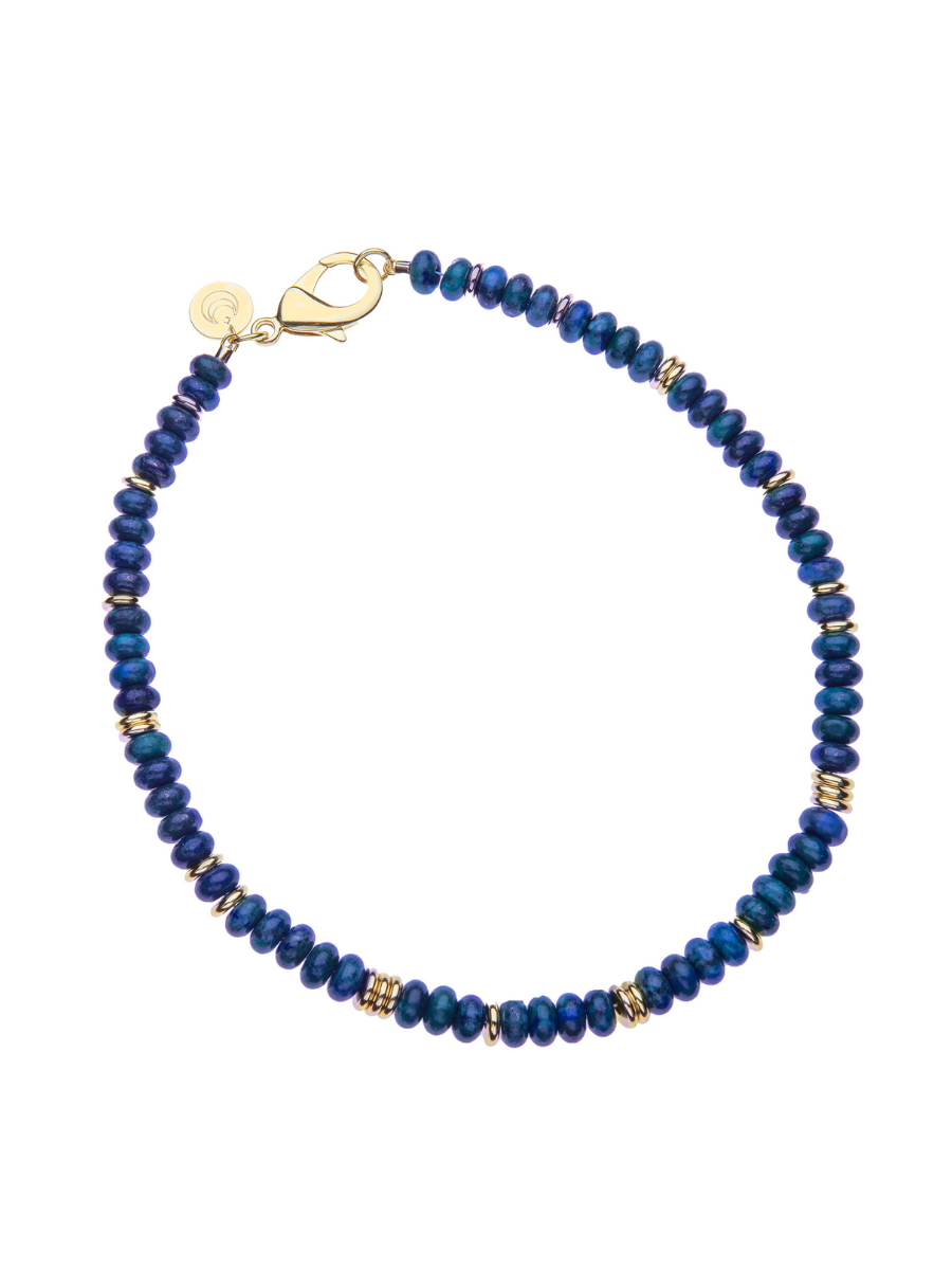 Blue beaded bracelet with gold accents on a white background