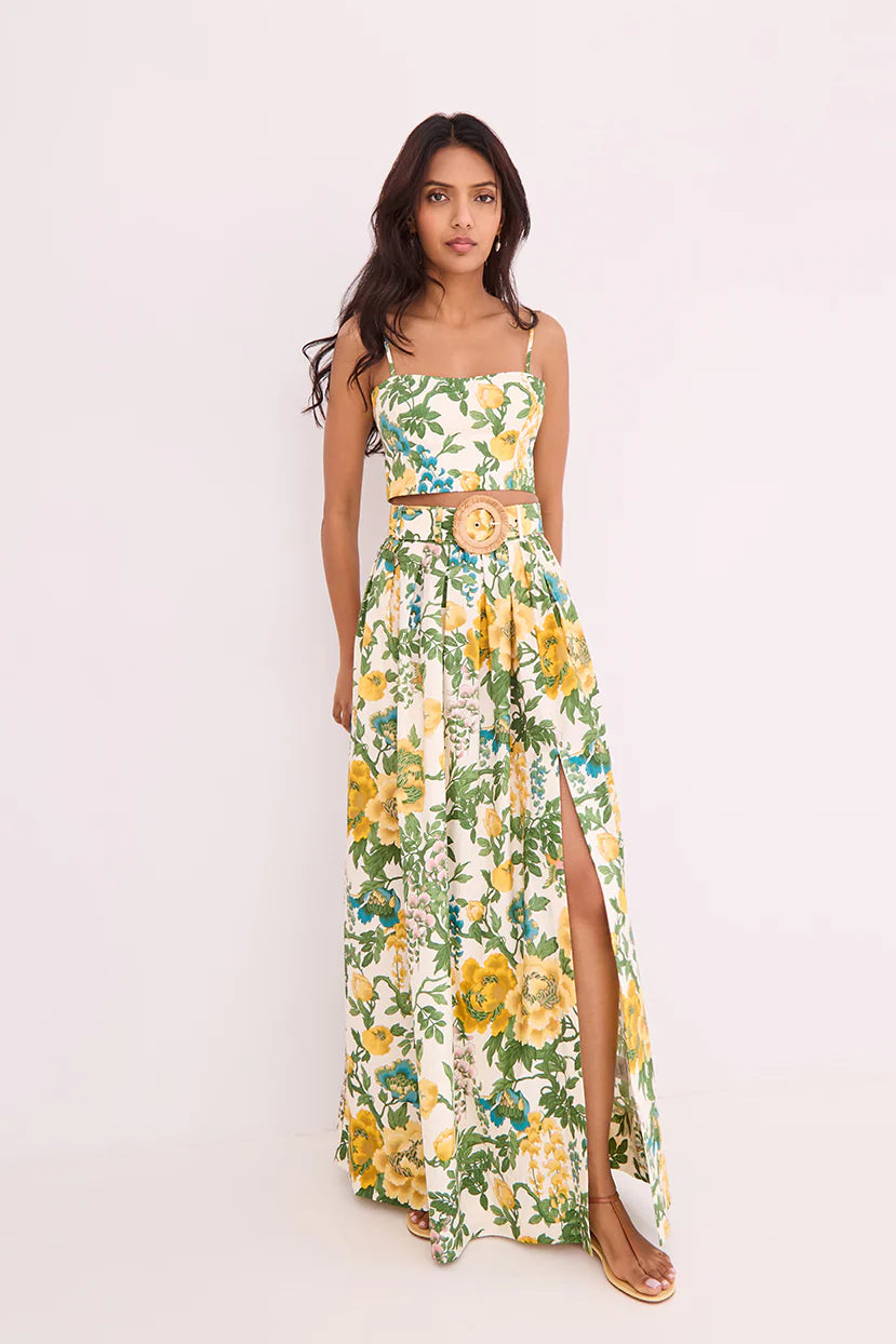 Woman wearing a floral dress with a belt on a light pink background