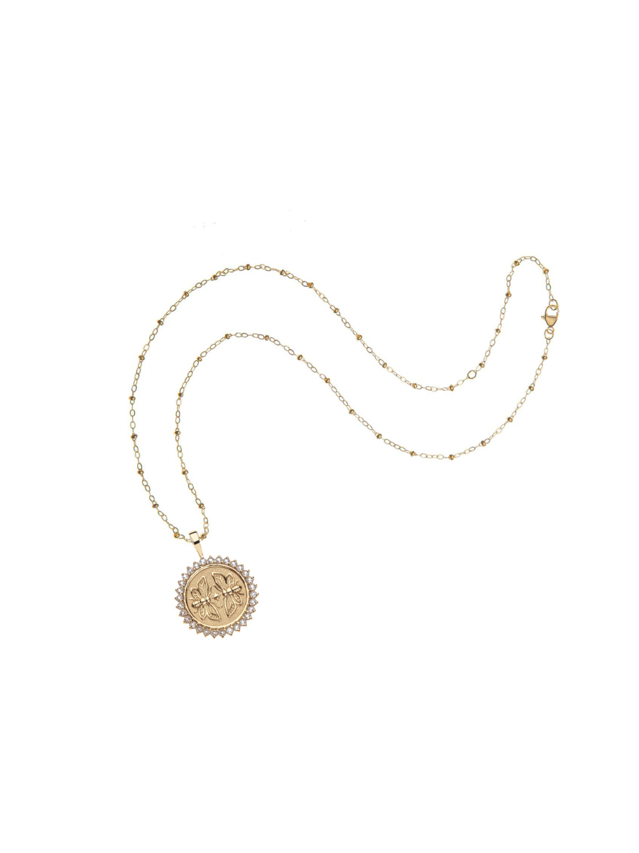 Gold necklace with a round pendant on a white background