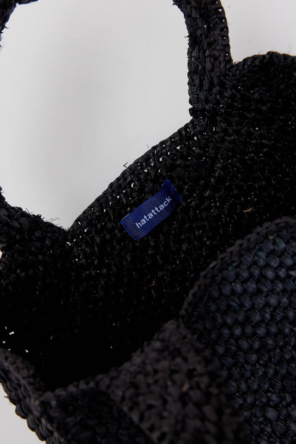 Black knitted hat with a brand label on a white background