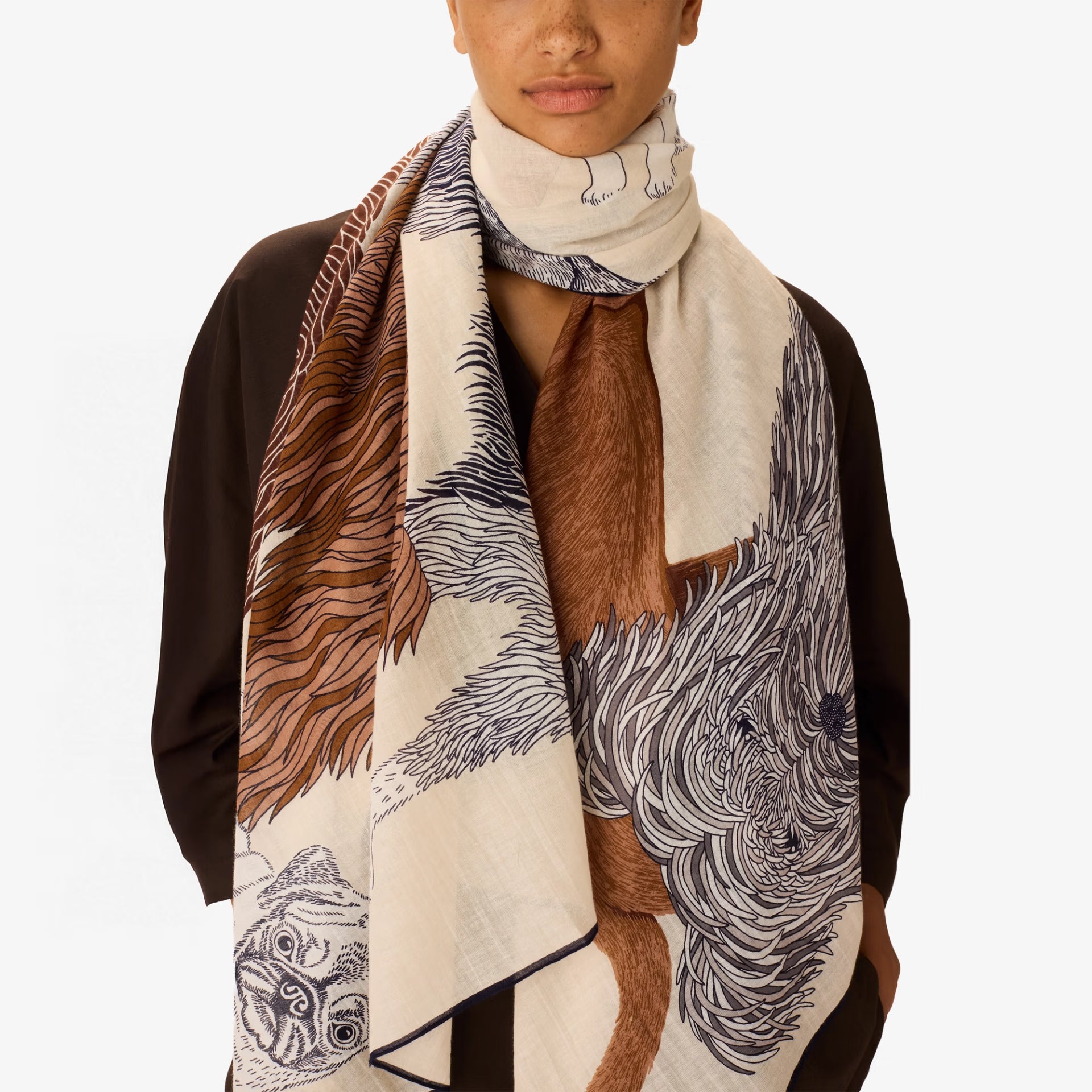 Person wearing a patterned scarf with brown, beige, and black design on a white background