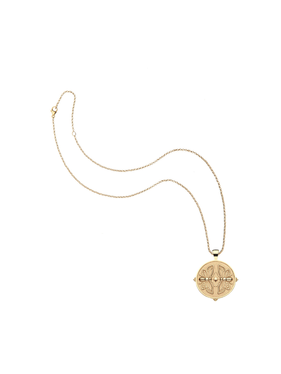 Gold necklace with a round pendant on a white background