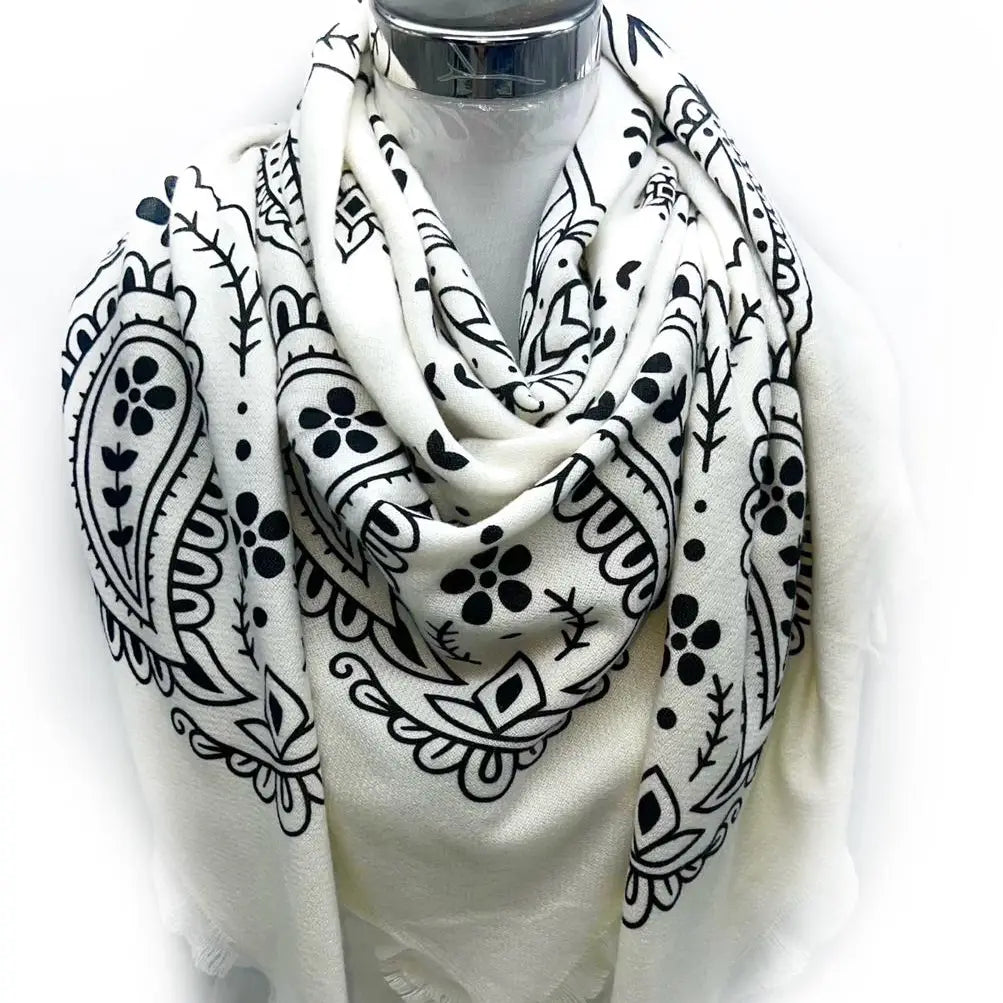 White scarf with black paisley patterns draped over a mannequin on a white background