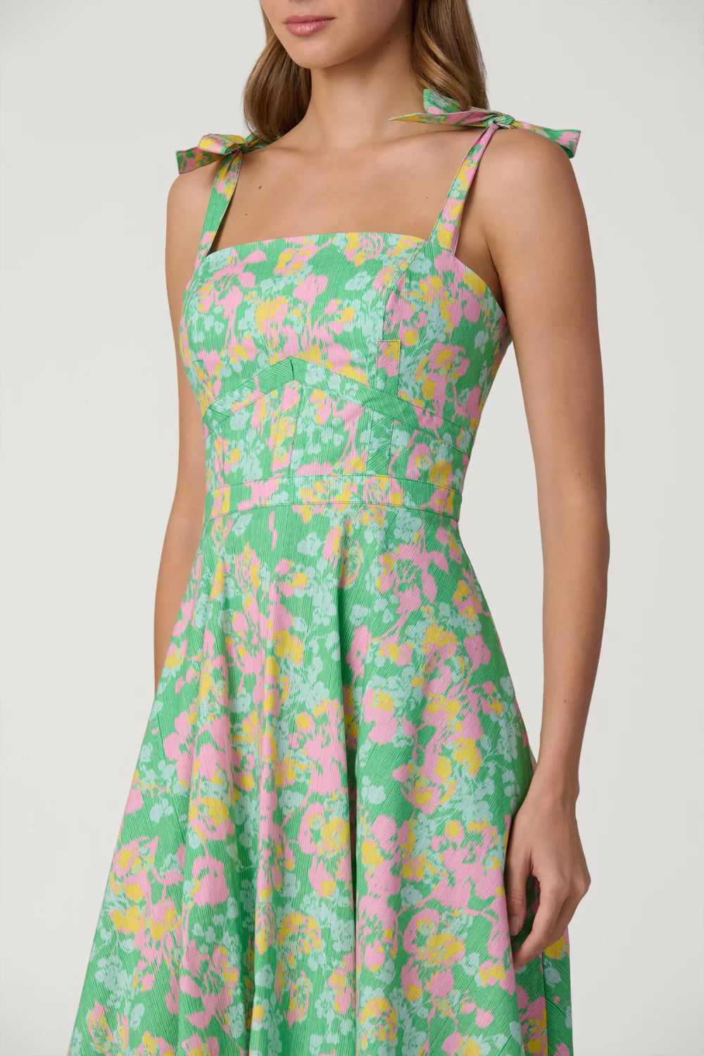 Green floral dress with pink and yellow flowers on a white background