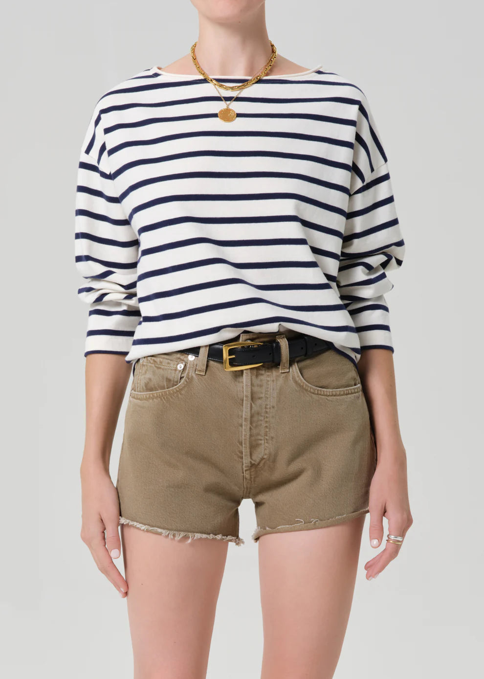 Person wearing a striped shirt and shorts on a plain background