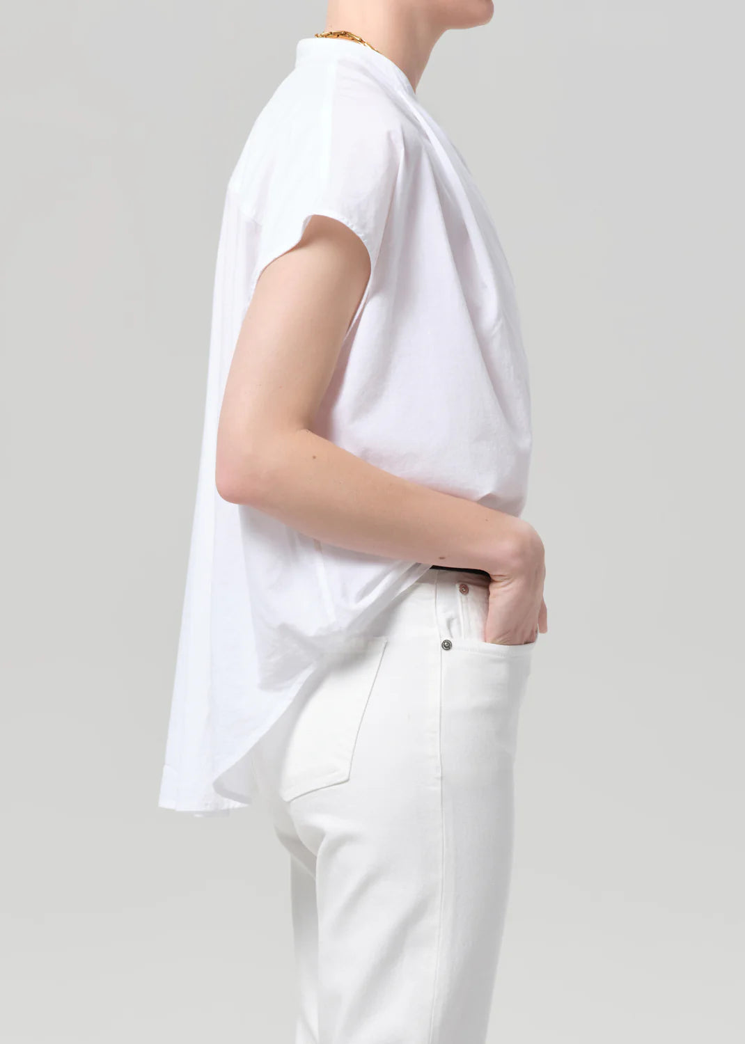 Person wearing a white t-shirt and pants on a plain background
