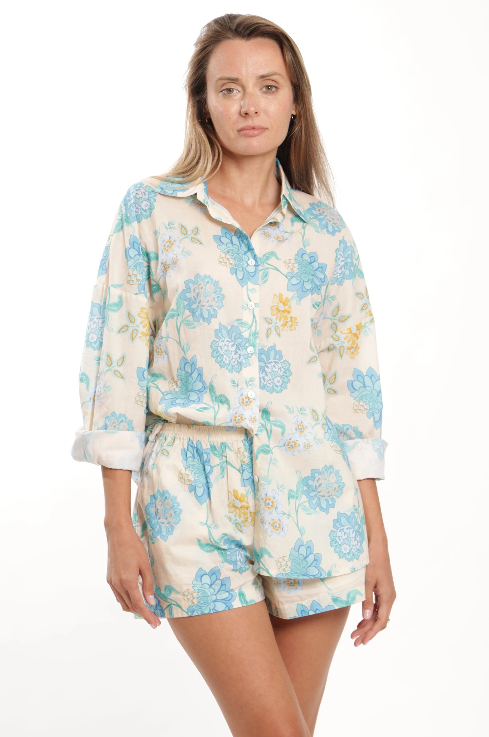Woman wearing a floral pajama set on a white background