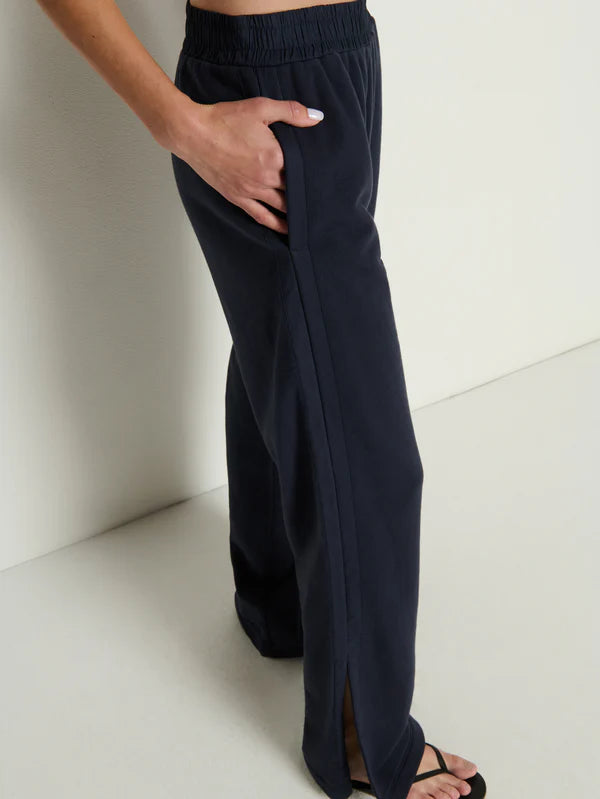 Person wearing navy blue pants on a light background