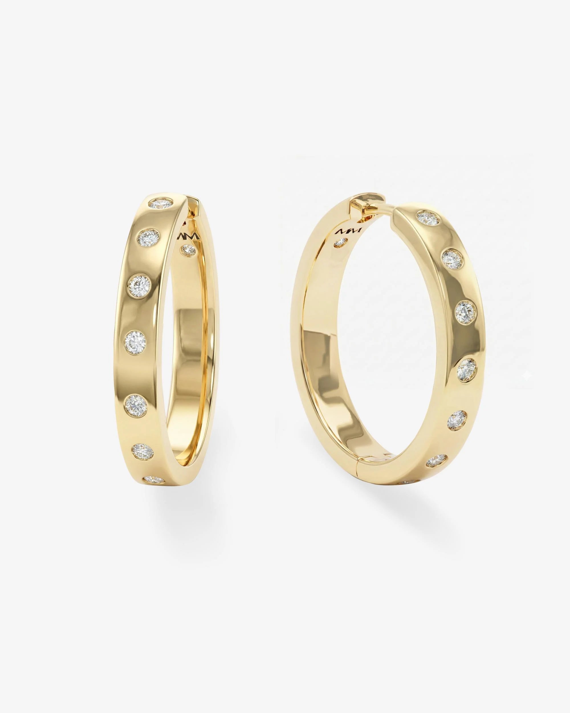 Gold hoop earrings with embedded diamonds on a white background