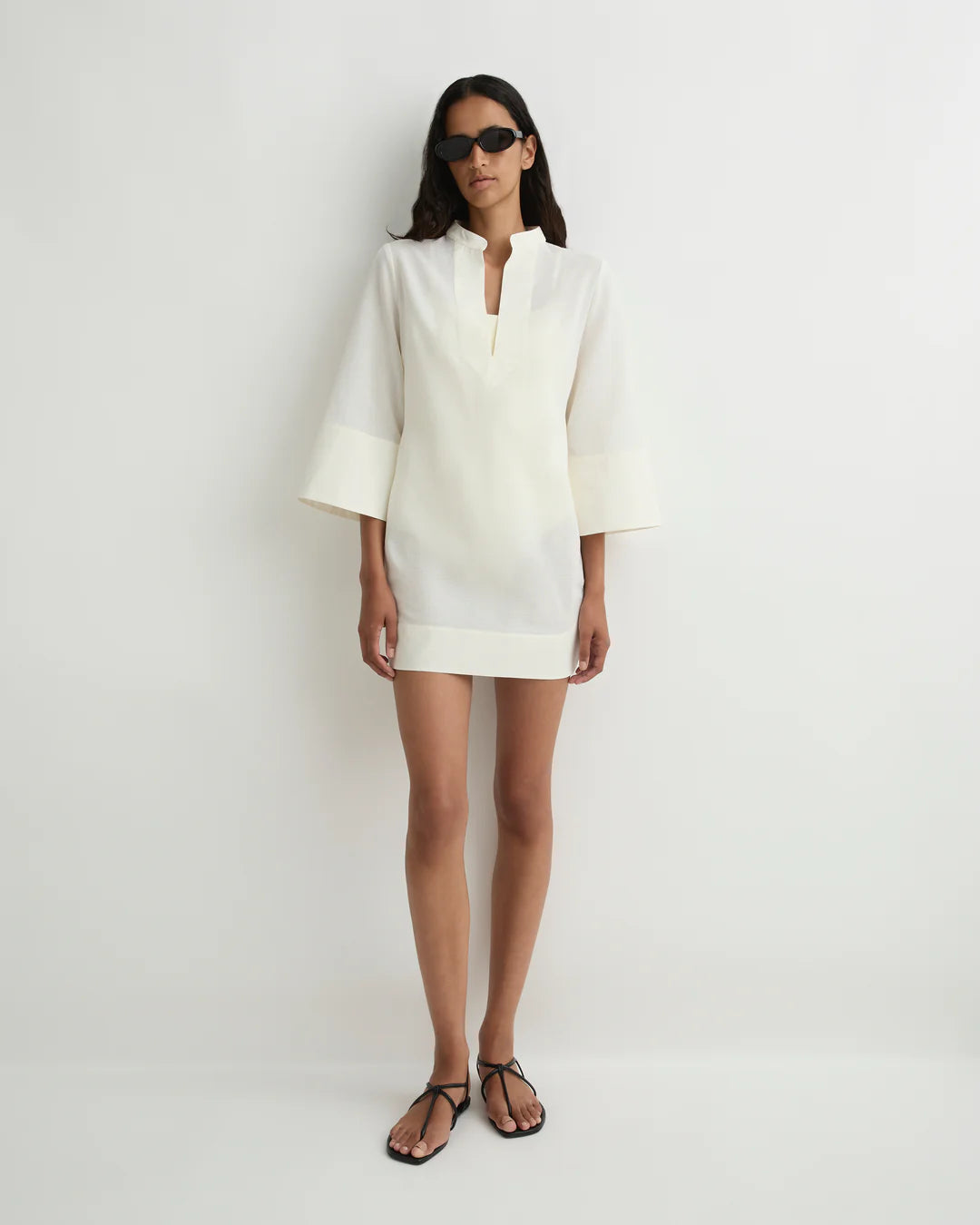 Woman wearing a white dress with a plain background