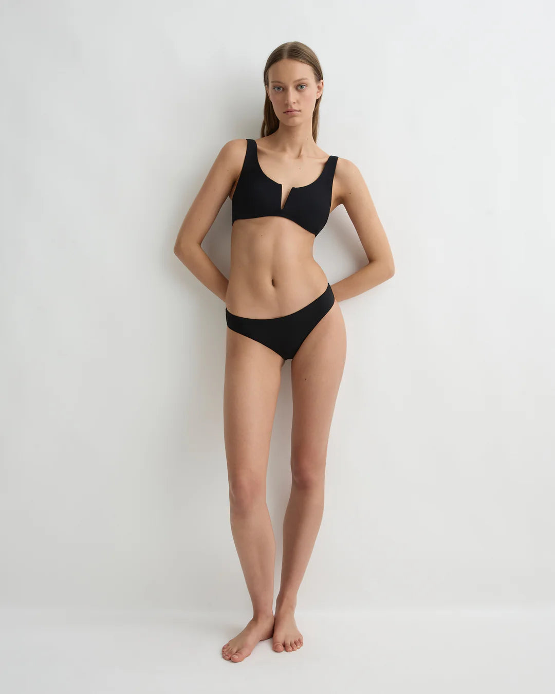Woman wearing a black bikini on a white background
