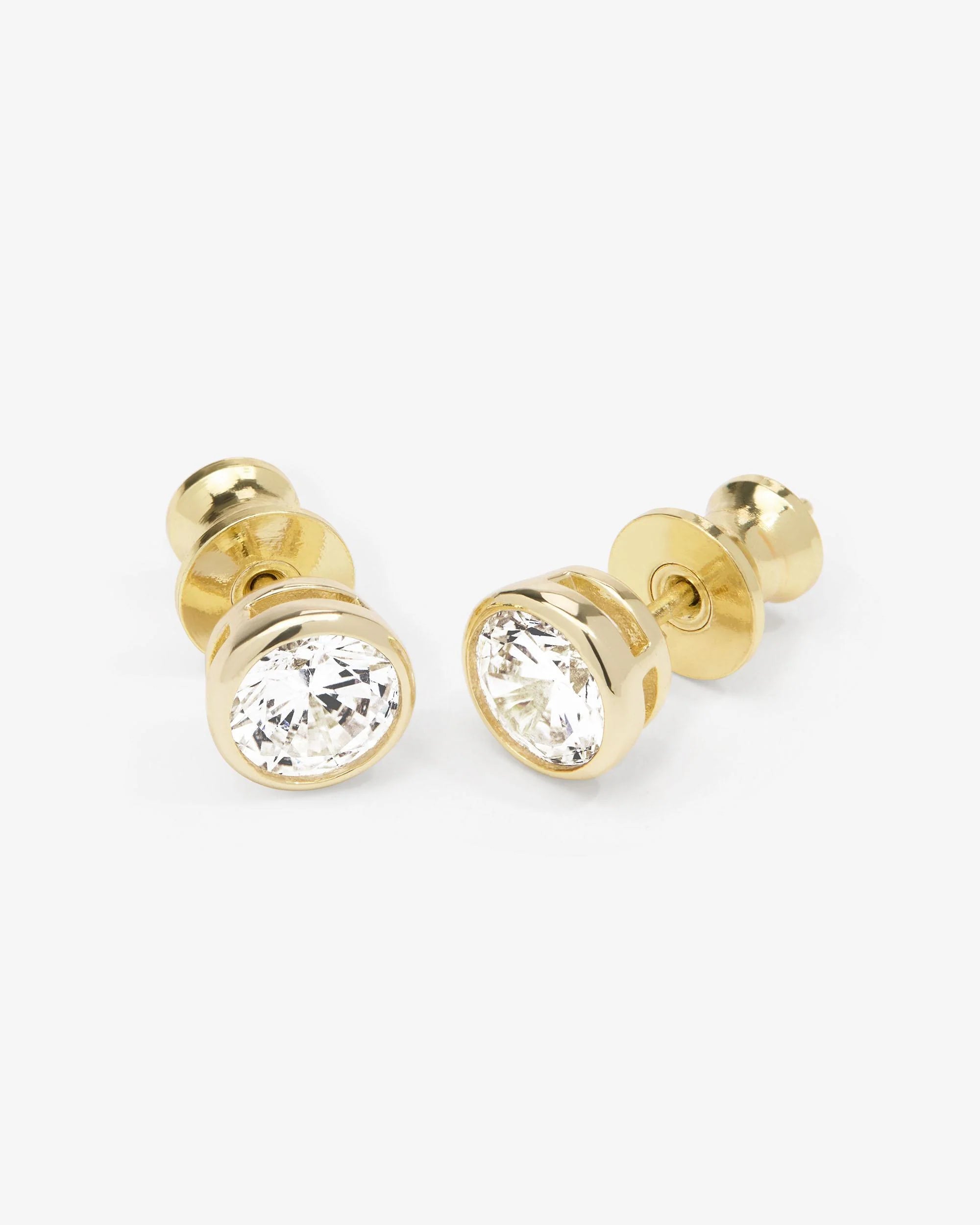 Gold stud earrings with clear gemstones on a white background