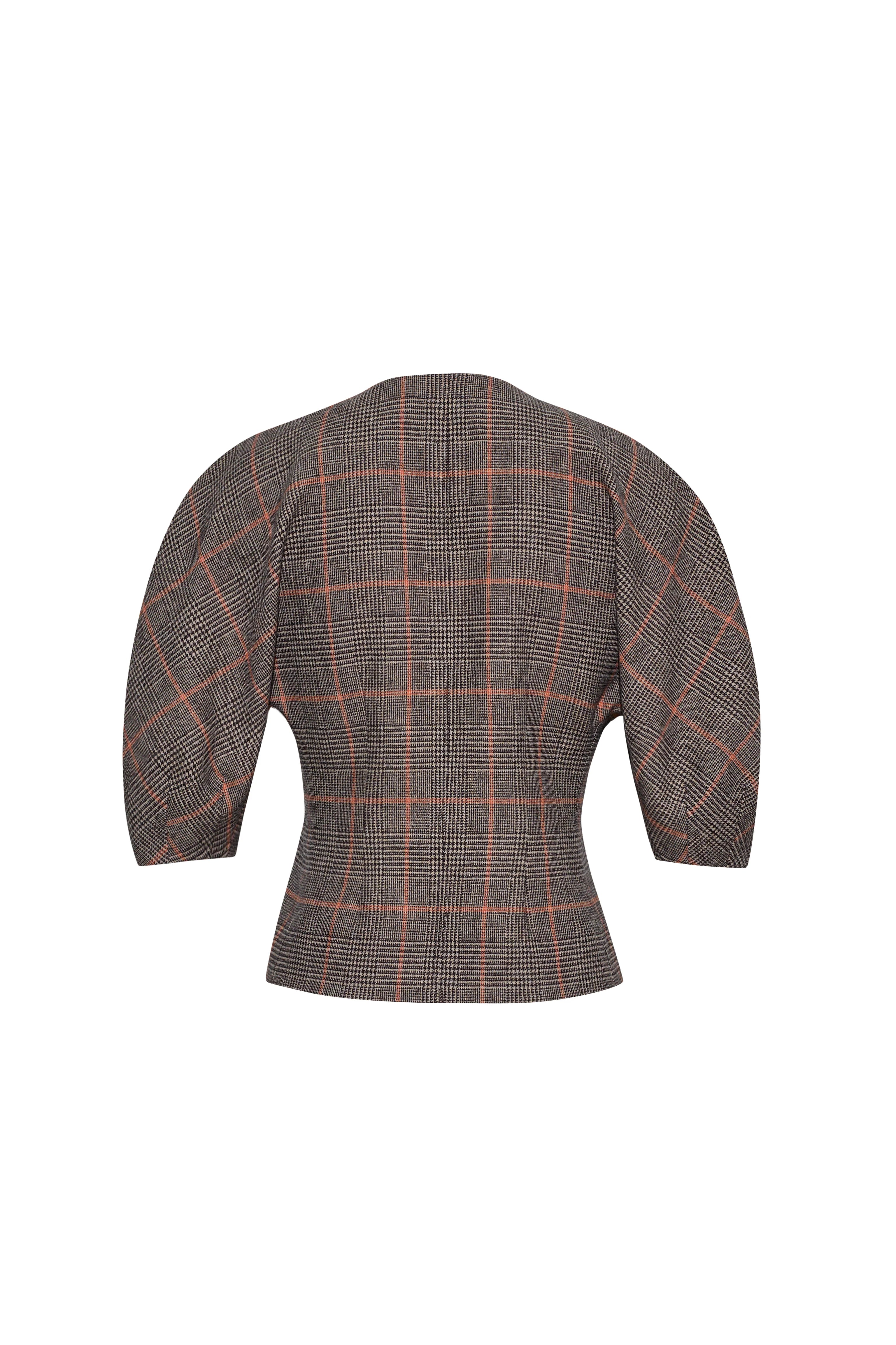A cropped, structured blazer shown from the back, featuring a brown and gray houndstooth pattern with a thin orange windowpane check.