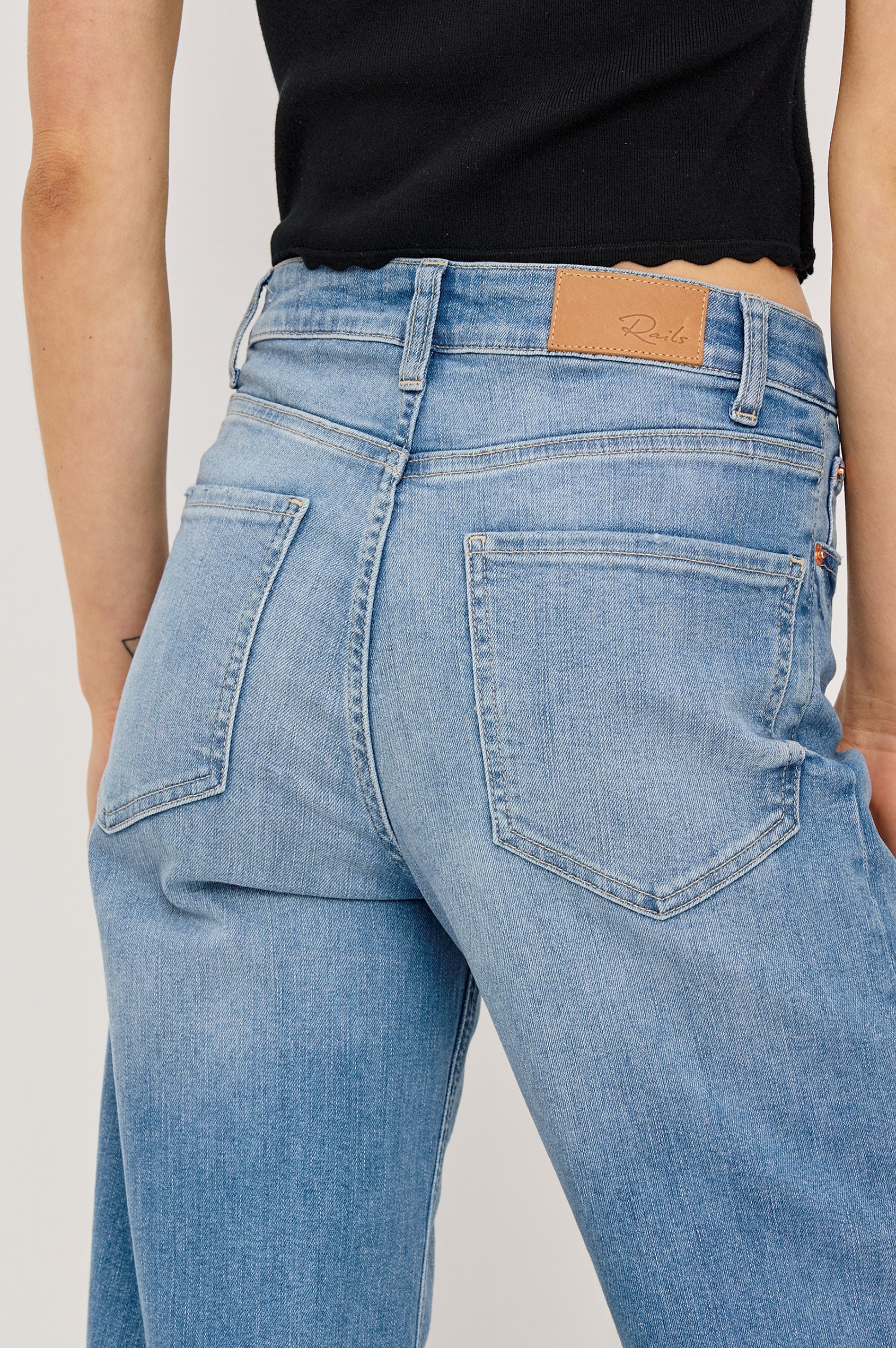 Light blue jeans with a brand logo on a plain background