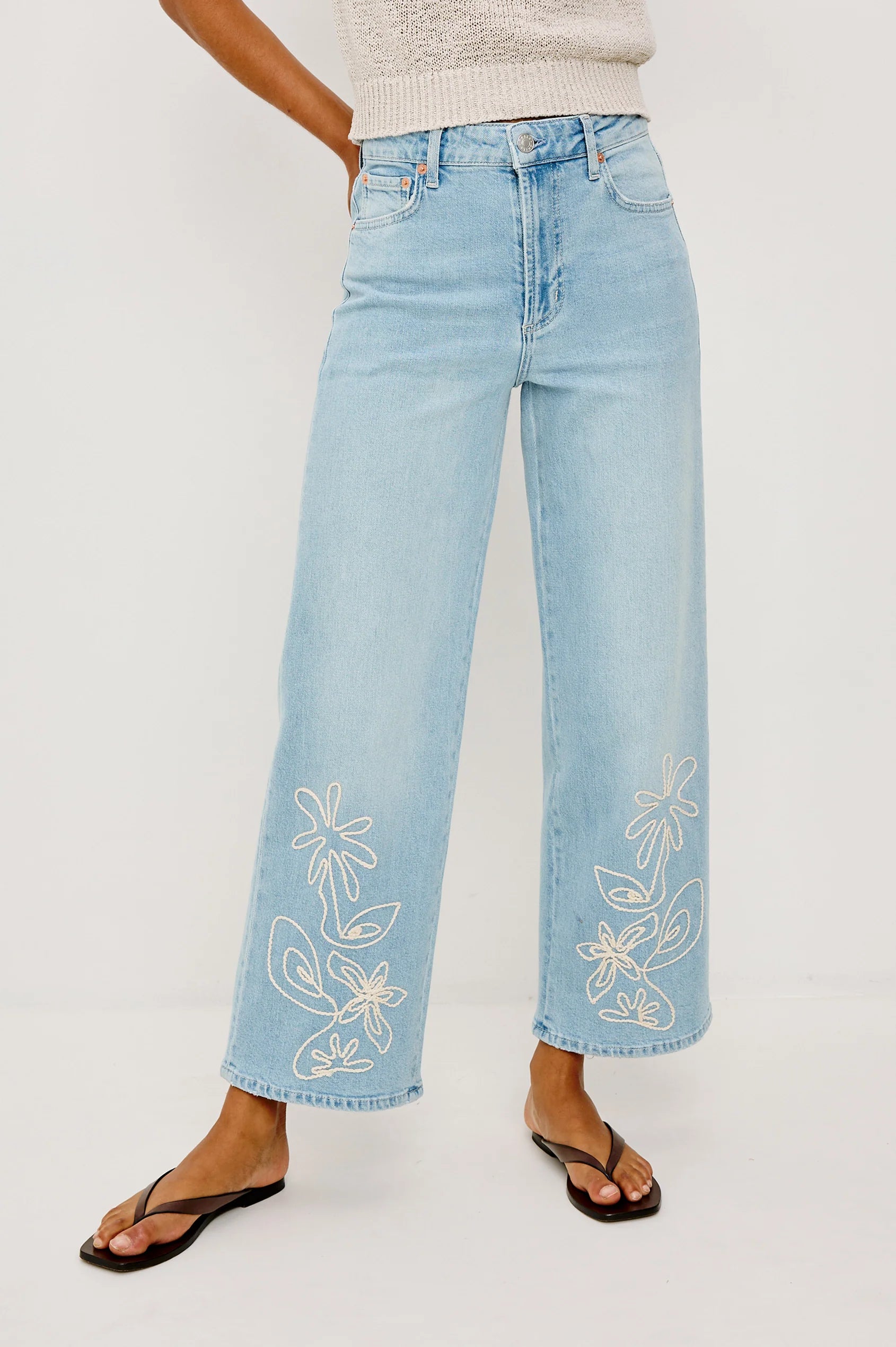 Light blue jeans with floral embroidery on a white background