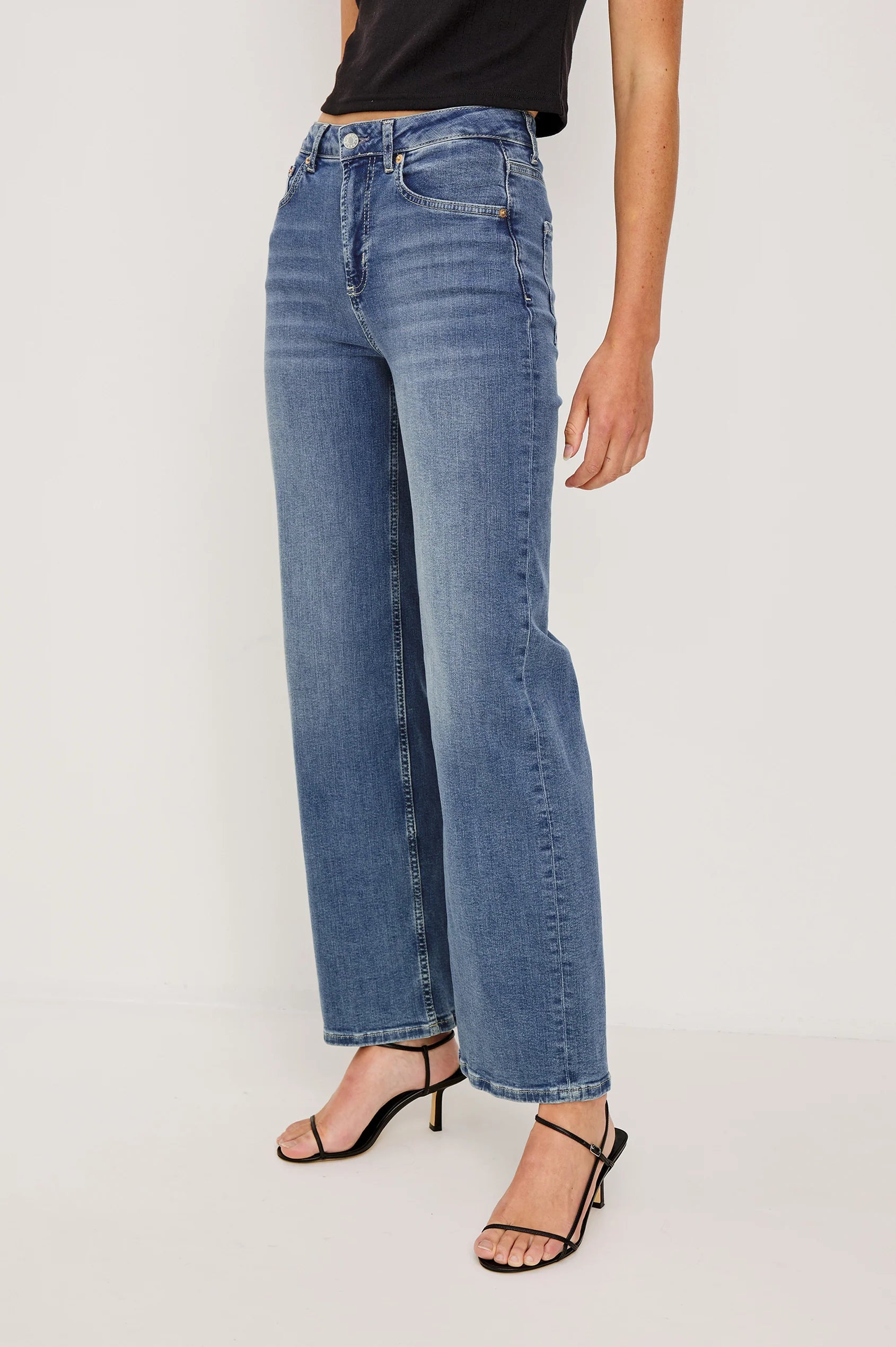 Person wearing blue jeans on a white background
