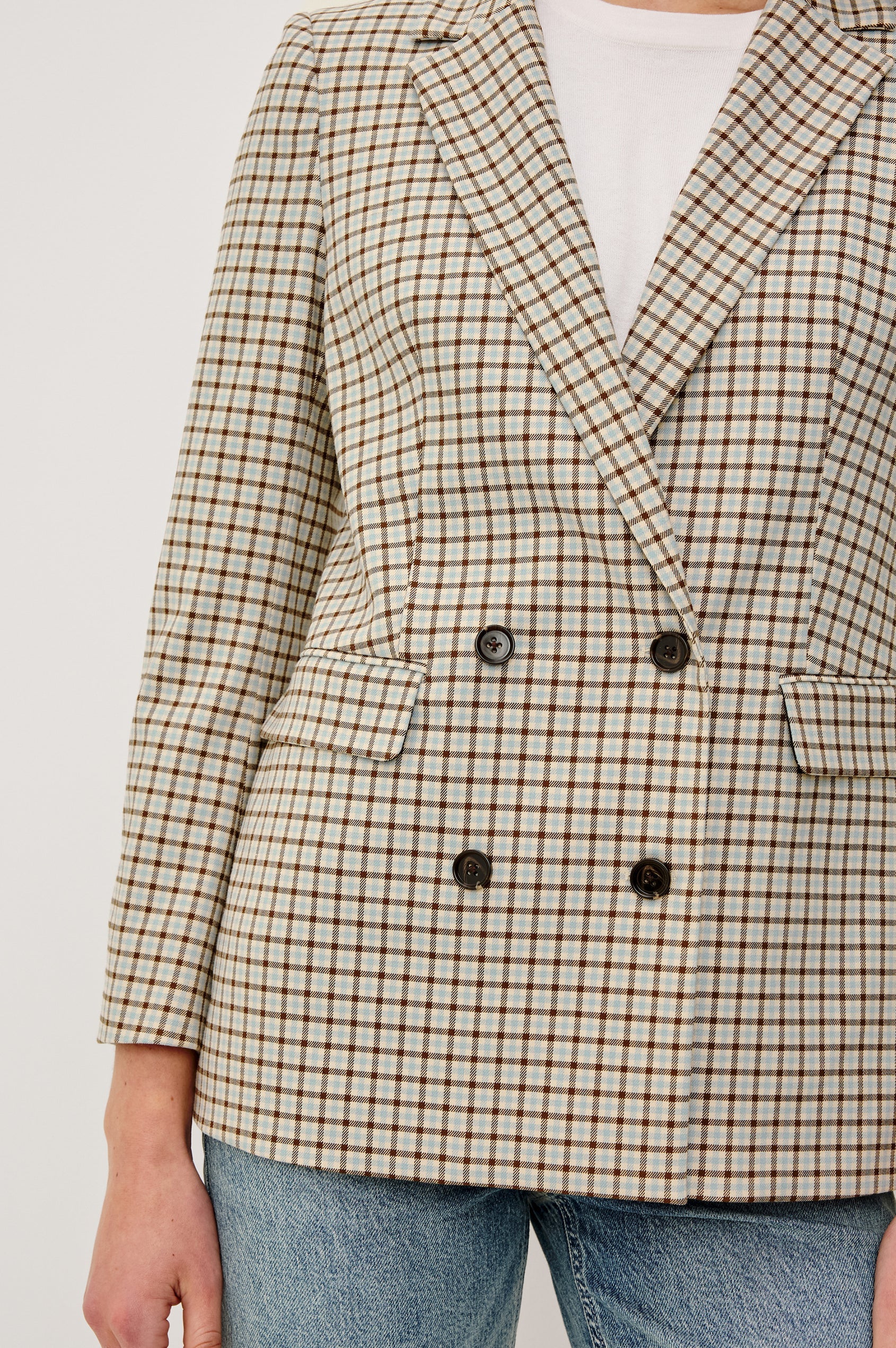 Plaid blazer with black buttons on a plain background