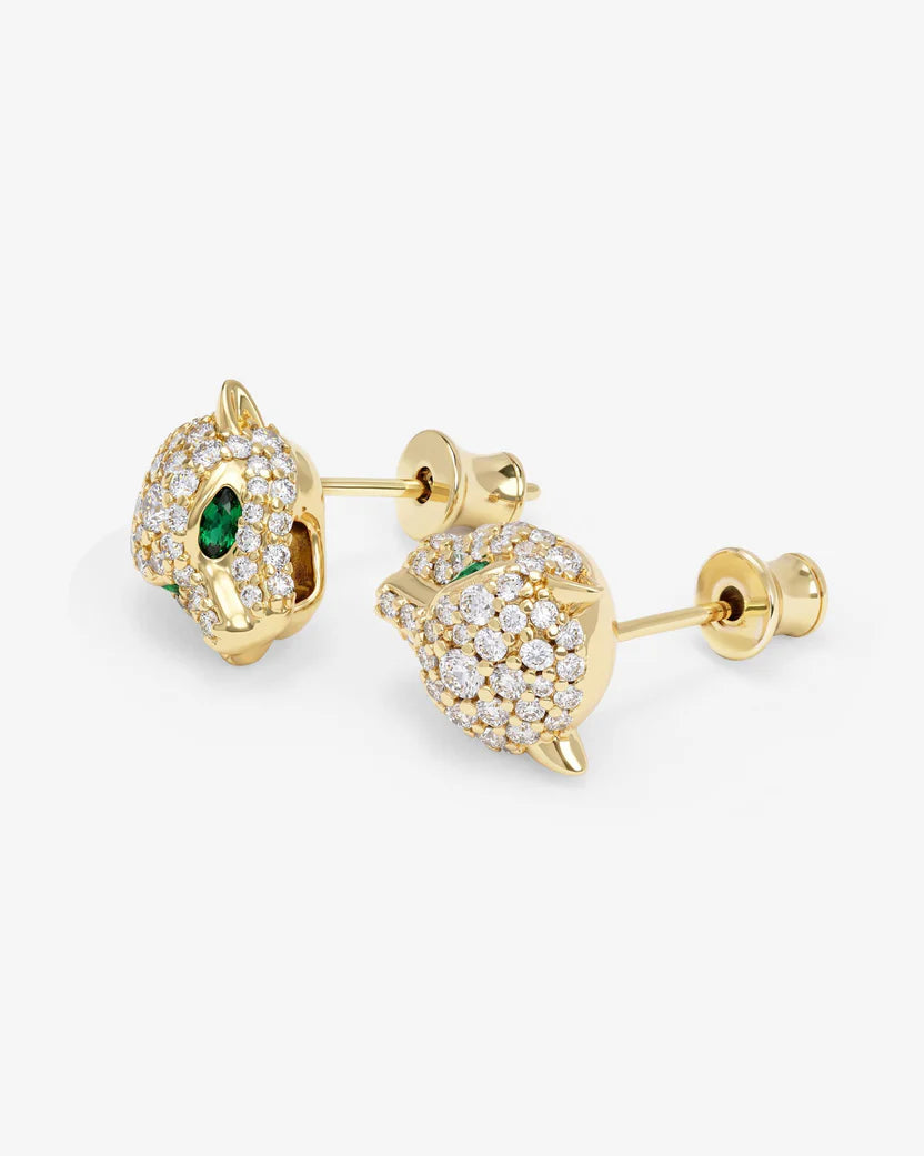 Gold earrings with green and clear gemstones on a white background