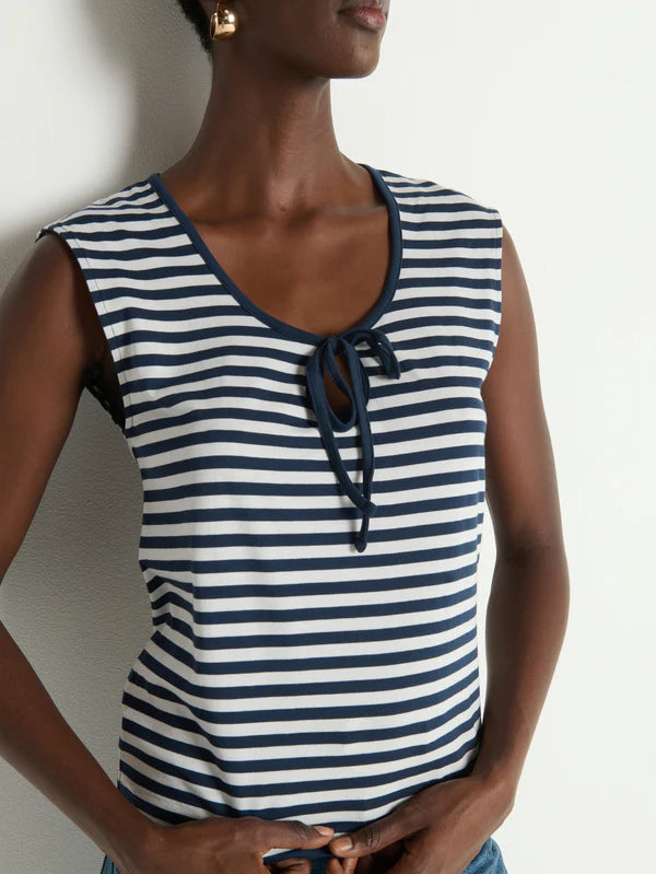 Woman wearing a blue and white striped sleeveless top against a plain background