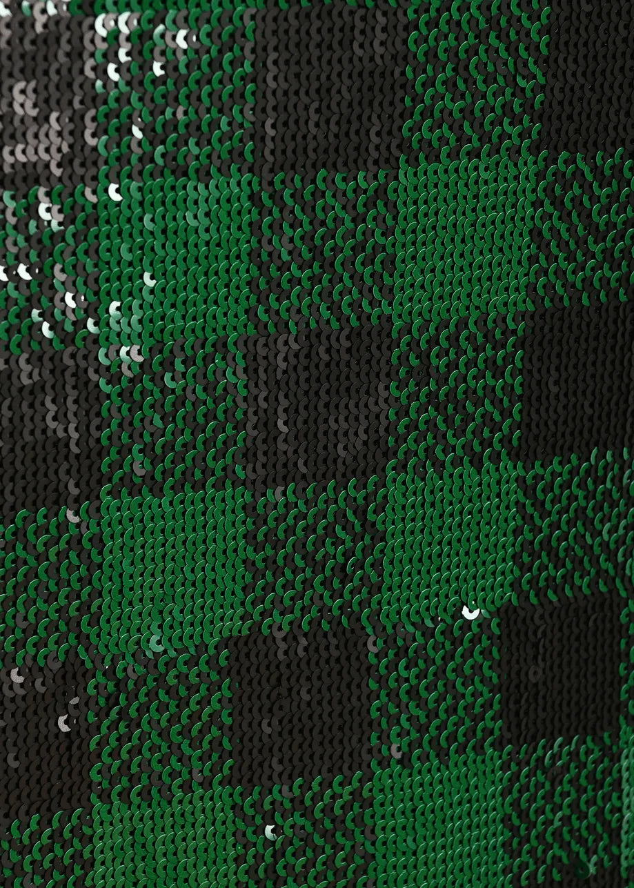 A close-up of a green and black sequin plaid pattern, showing the reflective texture of the sequins.