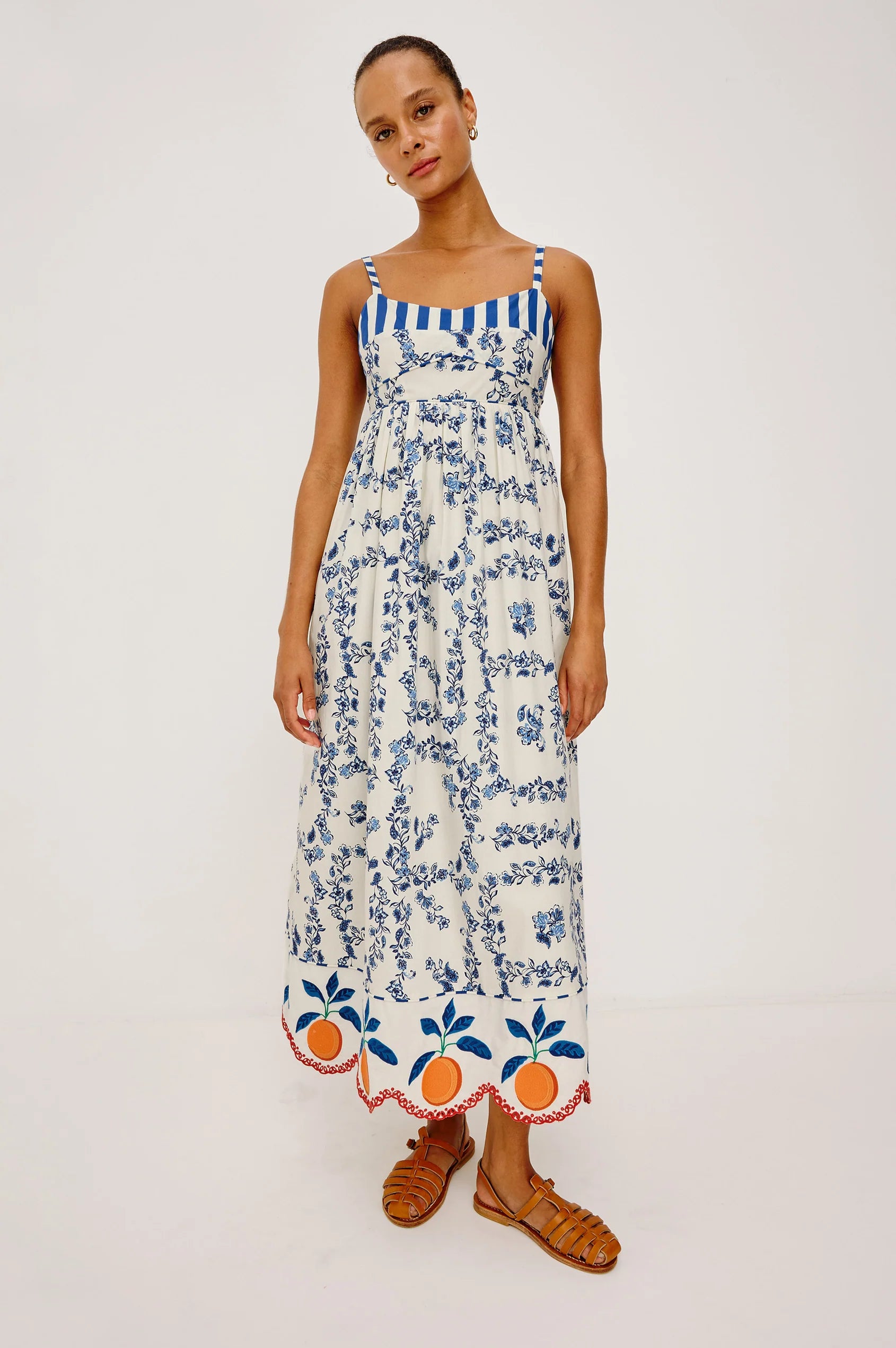Woman wearing a floral dress with blue accents on a white background