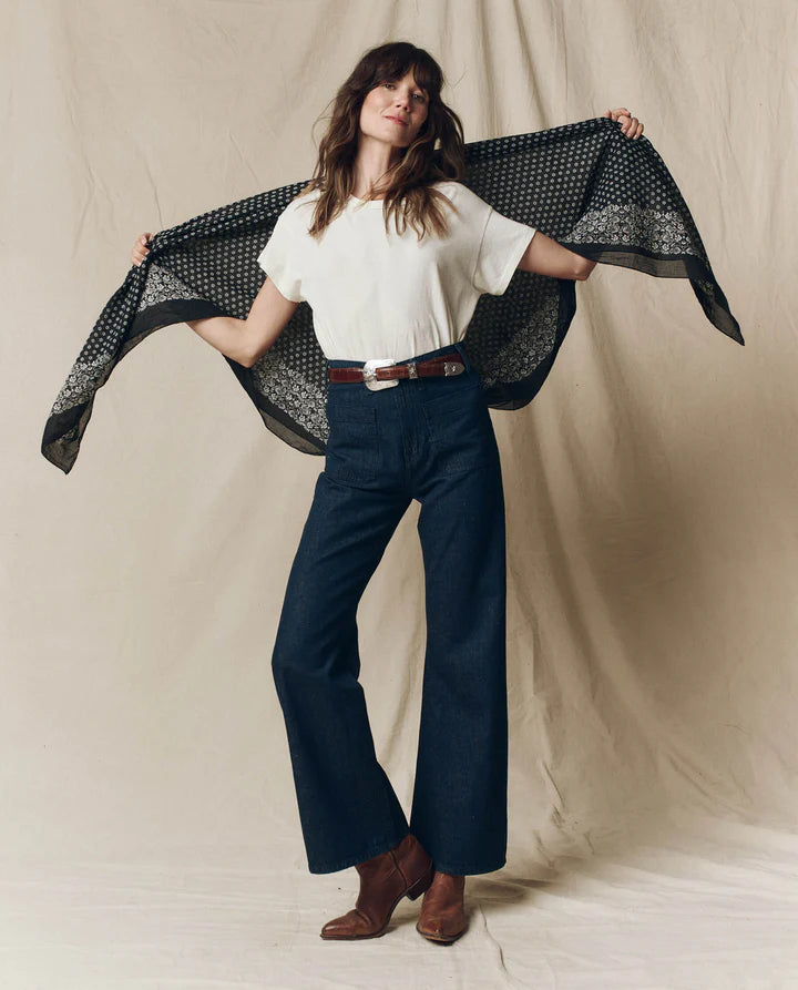Woman holding a black lace shawl against a beige background