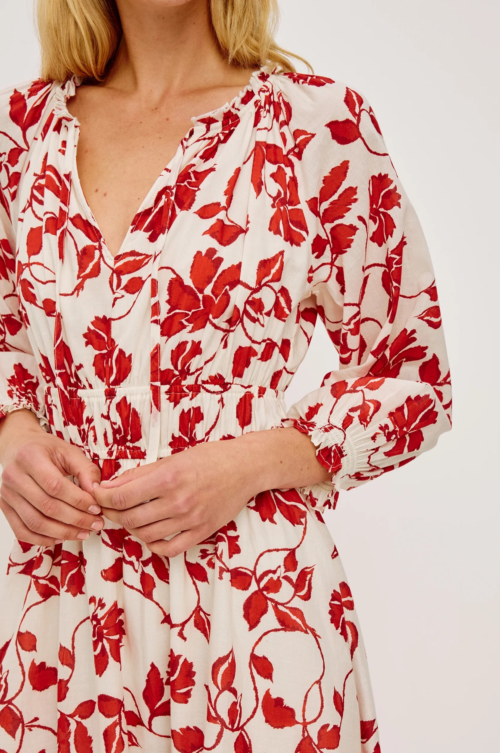 Red floral pattern on a white dress worn by a person