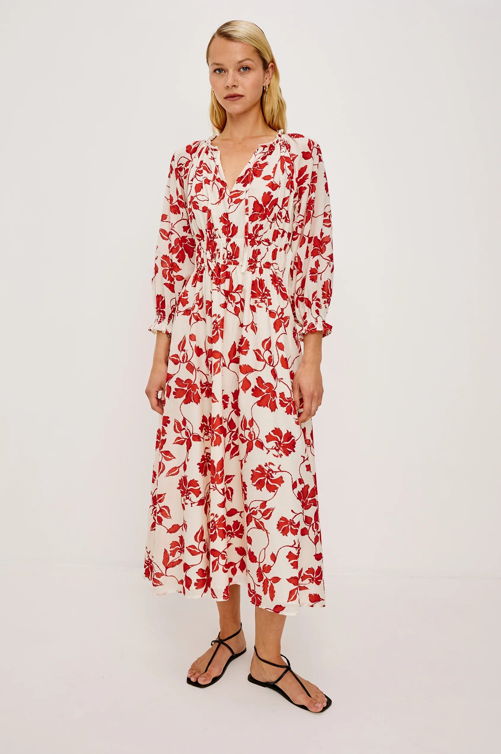 Woman wearing a red floral dress on a white background