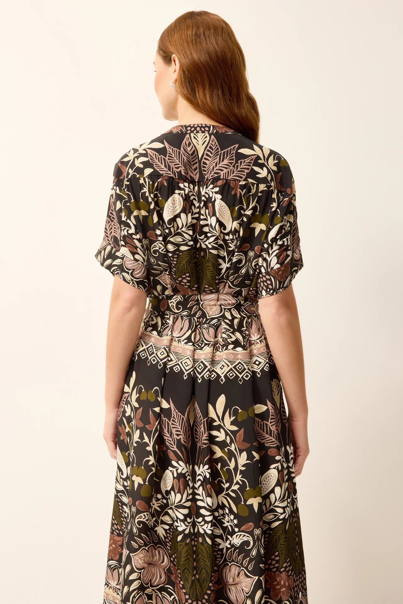 Woman wearing a patterned dress on a plain background