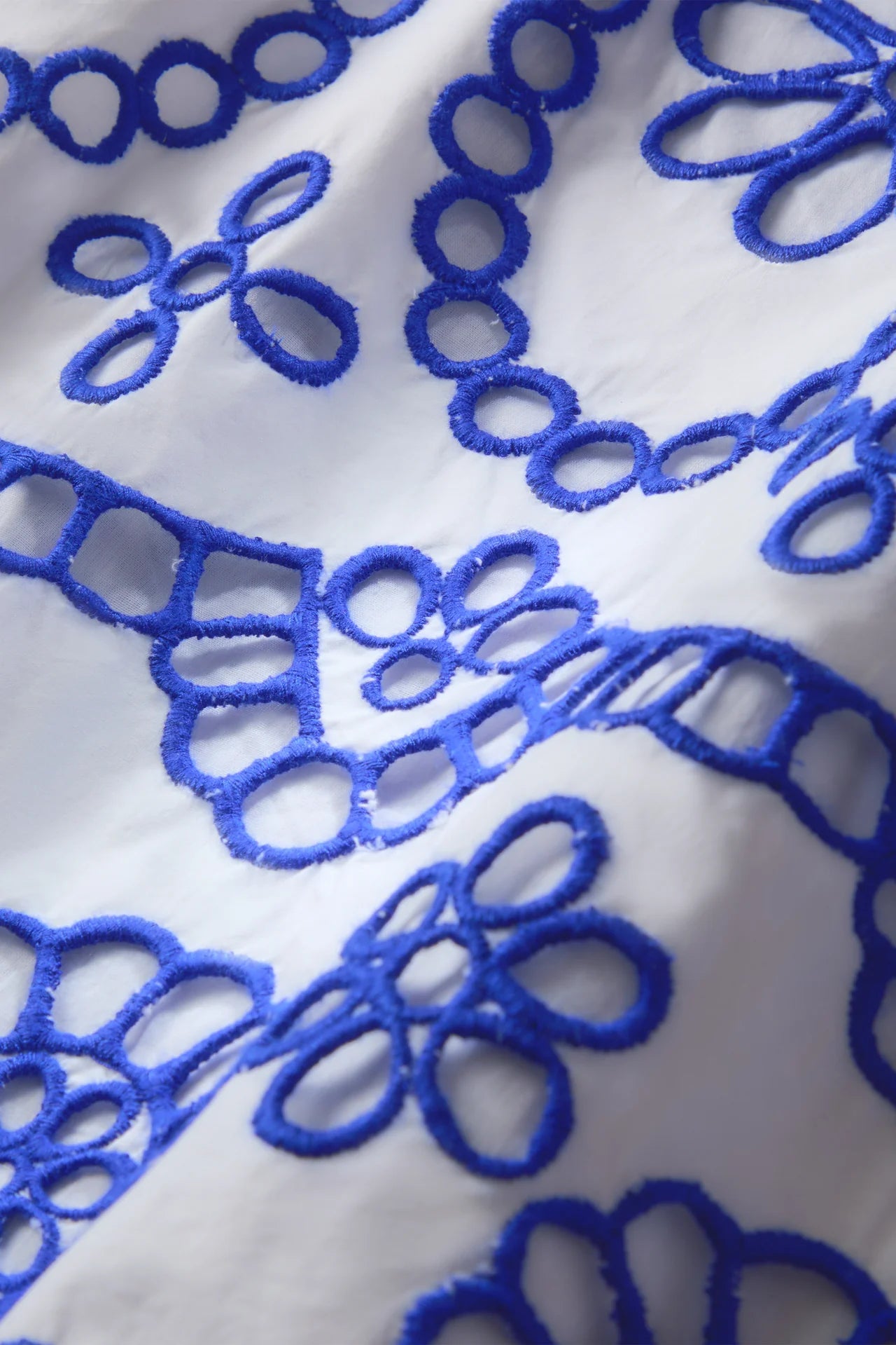 Close-up of blue embroidered pattern on white fabric