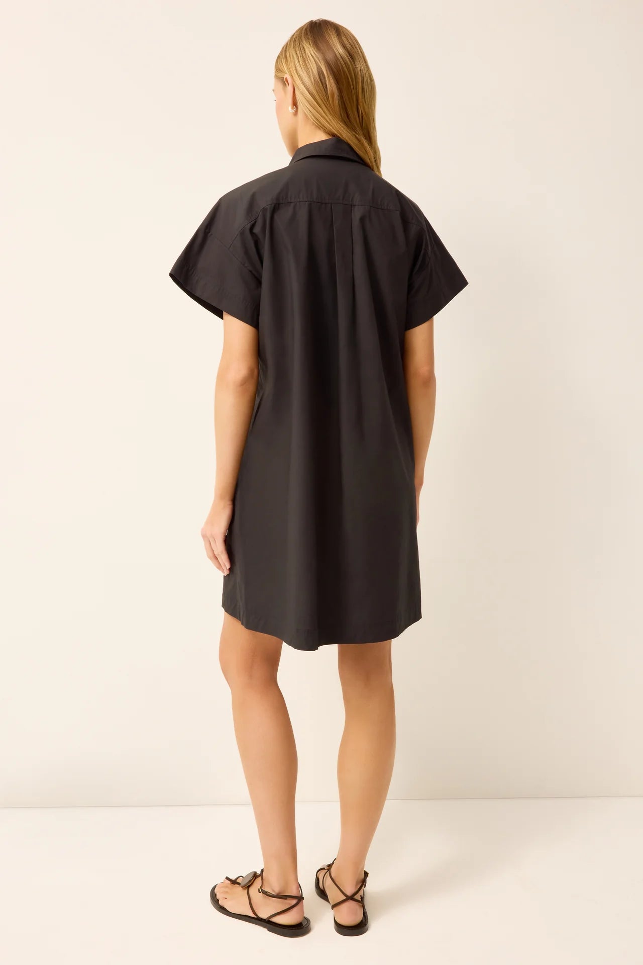 Woman wearing a black dress against a white background