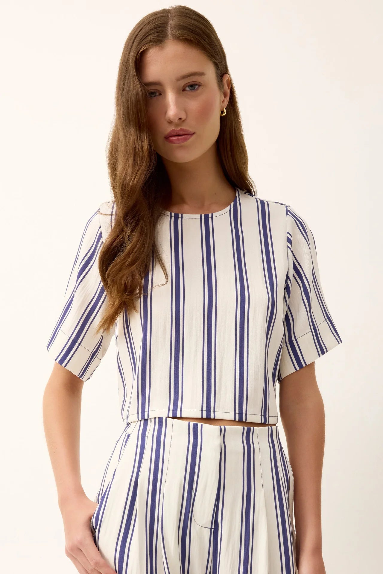 Woman wearing a blue and white striped outfit on a white background