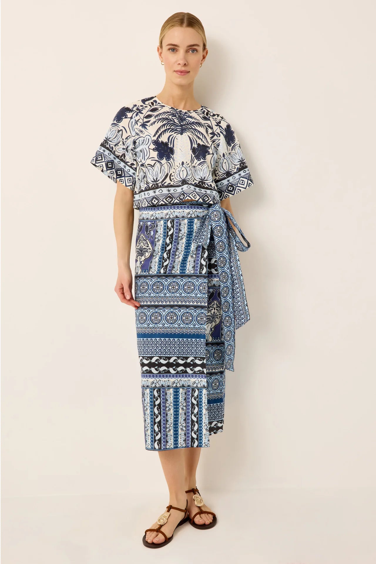 Woman wearing a blue and white patterned dress on a plain background