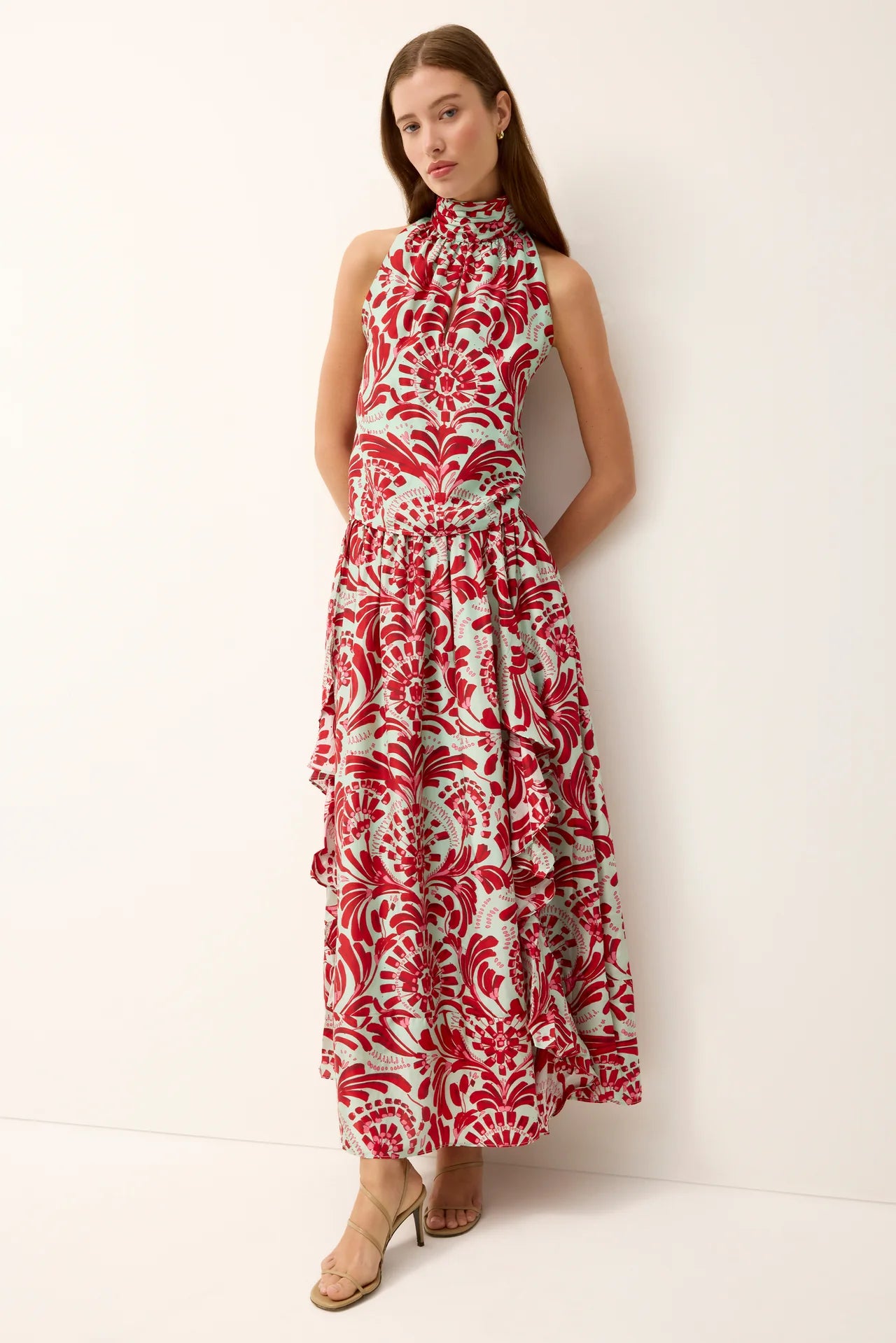Woman wearing a red and white patterned dress against a white background